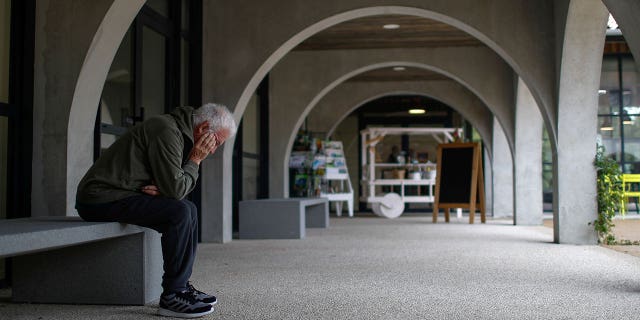 An Alzheimer's patient rests on a bench after walking at the Village Landais Alzheimer site in Dax, France, on Sept. 24, 2020.
