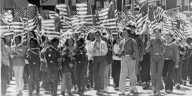 Dozens of youngsters from more than 120 area schools paraded through downtown Denver, Colo., with flags on June 12, 1976. The Flag Day parade was sponsored by Leyden-Chiles-Wickersham Post. No. 1, American Legion. 