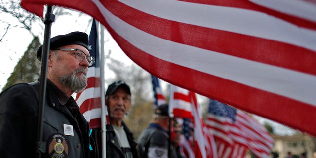 Mitch Laing of the American Legion Riders holds a flag with other members of the group outside the Performing Arts Center before a memorial service for Christine Loeber, Dr. Jennifer Gray Golick and Jennifer Gonzales Shushereba, on March 19, 2018, in Yountville, Calif.