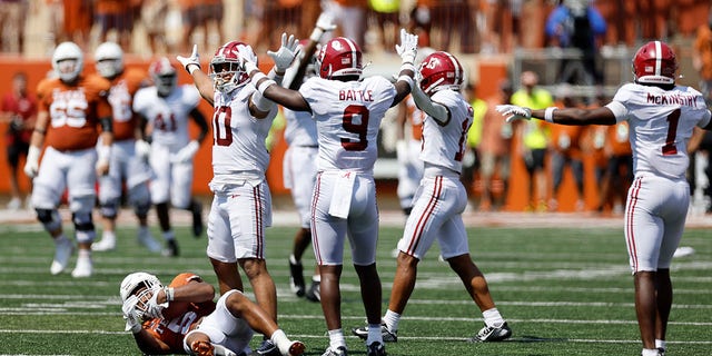 Henry To'oTo'o (10) of the Alabama Crimson Tide and Jordan Battle (9) celebrate after tackling Bijan Robinson (5) of the Texas Longhorns on the final play of the game at Darrell K Royal-Texas Memorial Stadium Sept. 10, 2022, in Austin, Texas.