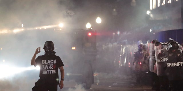 A Black Lives Matter demonstrator confronts police in front of the Kenosha County Courthouse during a third night of unrest on Aug. 25, 2020 in Kenosha, Wisconsin. 