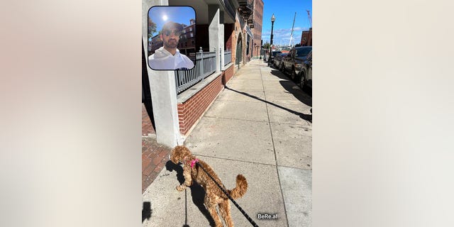 Zach Bowers snaps a BeReal photo while walking his dog, Ruby, in Boston's North End on Sept. 23, 2022.