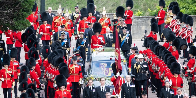 The casket of Queen Elizabeth II, carried in a state hearse as it proceeds toward St. George's Chapel, is followed by King Charles III and other members of the royal family, Sept. 19, 2022, in Windsor, England. 
