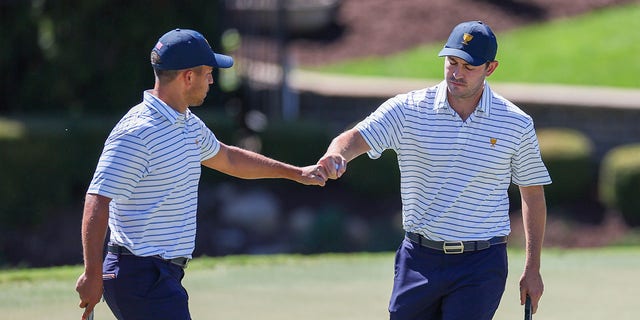 Team USA's Xander Schauffele and Patrick Cantlay celebrate on the seventh green during Friday's 4-ball match for the 2022 Presidents Cup at Quail Hollow Country Club in Charlotte, North Carolina, Sept. 23, 2022. .