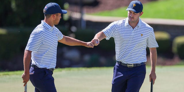 Team USA's Xander Schauffele and Patrick Cantlay celebrate on the seventh green during Friday's 4-ball match for the 2022 Presidents Cup at Quail Hollow Country Club in Charlotte, North Carolina, Sept. 23, 2022. .