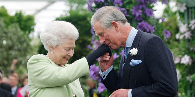 Queen Elizabeth II presents Prince Charles, Prince of Wales with the Royal Horticultural Society's Victoria Medal of Honour during a visit to the Chelsea Flower Show on May 18, 2009, in London. 