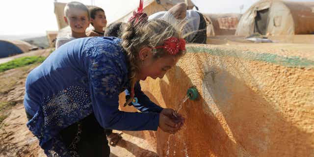 The World Health Organization has confirmed eight deaths from Cholera in Syria. Pictured: A woman drinks water from a fountain at Teh camp in northern Idlib, Syria, on May 5, 2021. 