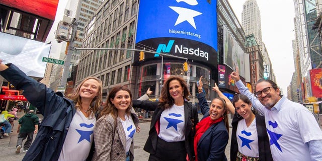 Claudia Romo Edelman, center, along with colleagues, points to the Hispanic Star shout-out by Nasdaq in Lower Manhattan. 
