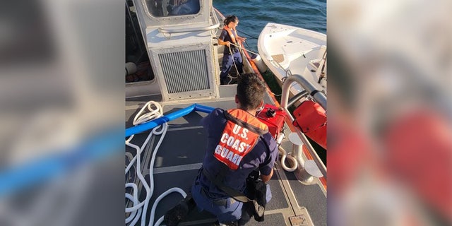 A crew with the U.S. Coast Guard Station Cortez works to dewater a boat off the Florida coast.