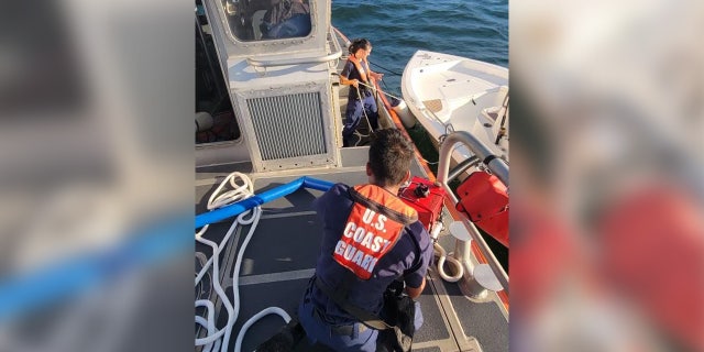 A crew with the U.S. Coast Guard Station Cortez works to dewater a boat off the Florida coast.