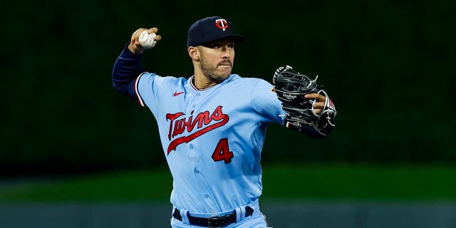 Carlos Correa of the Minnesota Twins throws to first base to get out Josh Harrison of the Chicago White Sox in a game at Target Field Sept. 27, 2022, in Minneapolis.  