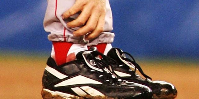 Pitcher Curt Schilling of the Boston Red Sox grabs at his ankle as it appears to be bleeding in the fourth inning during Game 6 of the American League Championship Series against the New York Yankees Oct. 19, 2004, at Yankee Stadium in the Bronx borough of New York City.