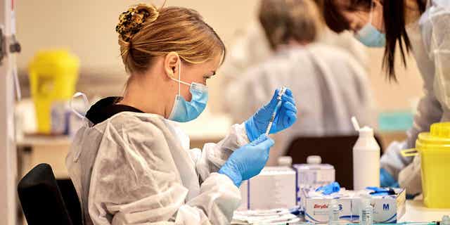 Although Denmark is slated to see an increase in COVID cases during this winter, a Danish health minister has revealed that the country will not institute more regulations. Pictured: A health care worker loads up a dose of the COVID vaccine for nursing home residents in Copenhagen, Denmark, on Jan. 23, 2021.