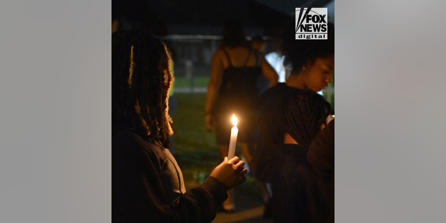 Friends and relatives of Devin Clark gather in downtown Yanceyville, North Carolina Thursday, September 22, 2022, for a vigil in honor of the 18-year-old who was found shot dead along with 14-year-old Lyric Woods in Mebane, North Carolina