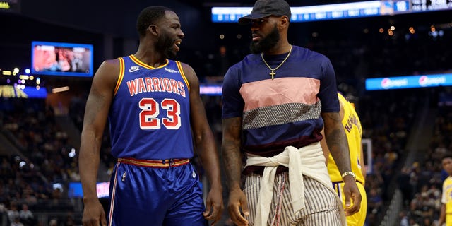 Draymond Green (23) of the Golden State Warriors talks with injured LeBron James of the Los Angeles Lakers at Chase Center April 7, 2022, in San Francisco. 