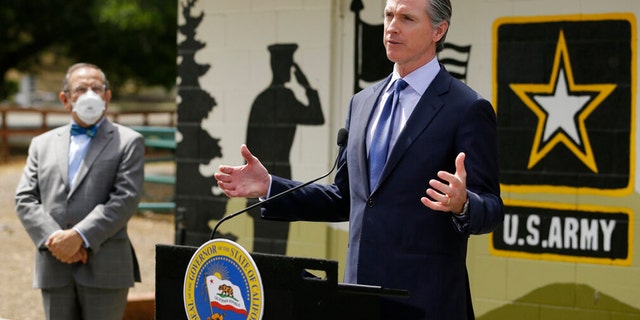 FILE: California Gov. Gavin Newsom speaks during a news conference as CalVet Secretary Vito Imbasciani looks on at the Veterans Home of California, Friday, May 22, 2020, in Yountville, Calif.