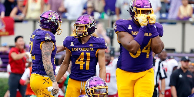 East Carolina's Luke Larsen, 12, was the kicker after a failed field goal attempt against North Carolina State University in the second half of an NCAA college football game in Greenville, North Carolina, Sept. 3, 2022. Comforting Owen Duffer (41).