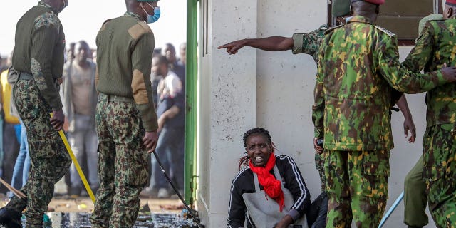 A woman lies on the floor after being crushed in a stampede when security forces kept others back, after they forced their way into Kasarani stadium where the inauguration of Kenya's new president William Ruto is due to take place later today, in Nairobi, Kenya Tuesday, Sept. 13, 2022. 