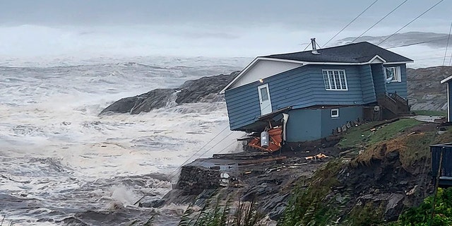 A home fights against high winds caused by post Tropical Storm Fiona in Port aux Basques, Newfoundland and Labrador, on Saturday. The home has since been lost at sea.
