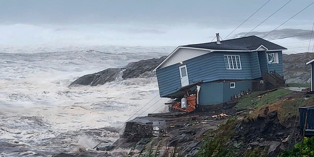 A home fights against high winds caused by post Tropical Storm Fiona in Port aux Basques, Newfoundland and Labrador, on Saturday. The home has since been lost at sea.