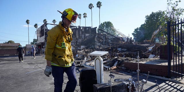 A Los Angeles fireman recovers musicals instruments after a fire destroyed the Victory Baptist Church in Los Angeles, California, on Sept. 11, 2022. 
