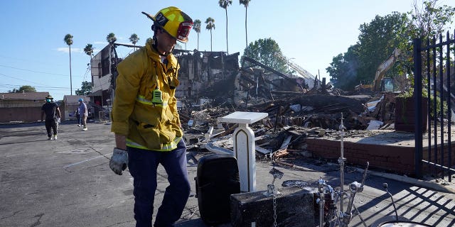 A Los Angeles fireman recovers musicals instruments after a fire destroyed the Victory Baptist Church in Los Angeles, California, on Sept. 11, 2022.