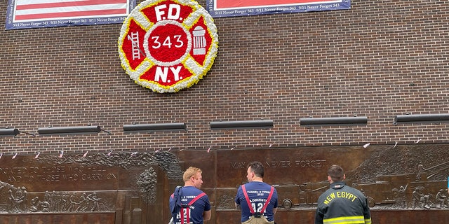 Firefighters at the FDNY memorial wall in Lower Manhattan. Police say the suspect in the Harlem smoke shop shooting wore a jacket with the FDNY letters on the back.