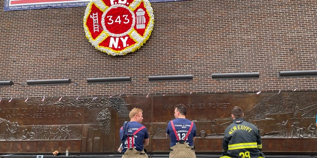 Firefighters reflect at the FDNY memorial wall in Lower Manhattan following the Tunnel to Towers annual 5K on Sept. 25, 2022.