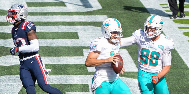 Ryan Fitzpatrick (14) celebrates with teammate Mike Gesicki (88) of the Miami Dolphins after scoring a two-point conversion against the New England Patriots at Gillette Stadium in Foxborough, Mass., Sept. 13, 2020.