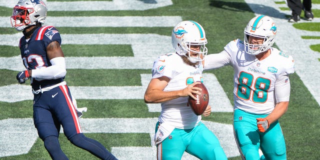 Ryan Fitzpatrick (14) celebrates with teammate Mike Gesicki (88) of the Miami Dolphins after scoring a two-point conversion against the New England Patriots at Gillette Stadium in Foxborough, Mass., Sept. 13, 2020.