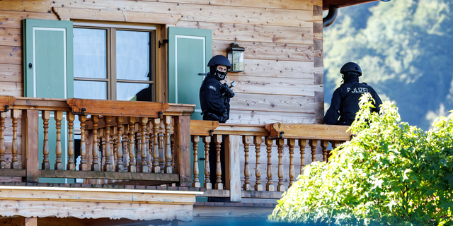 Masked police officers stand on a balcony of a house belonging to Russian oligarch Usmanov during a raid in Rottach-Egern, Germany, Wednesday, Sept.21, 2022.