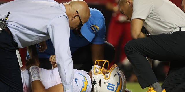 Trainers attend to Los Angeles Chargers quarterback Justin Herbert in the fourth quarter of the game against the Kansas City Chiefs at Arrowhead Stadium in Kansas City, Missouri, on Thursday.