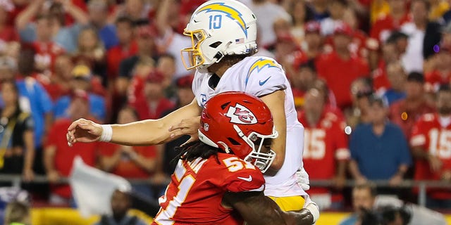 Kansas City Chiefs defensive end Mike Danna, #51, puts a hard hit on Los Angeles Chargers quarterback Justin Herbert, #10, in the fourth quarter of an NFL game between the Los Angeles Chargers and Kansas City Chiefs on Sept. 15, 2022 at GEHA Field at Arrowhead Stadium in Kansas City, Missouri.