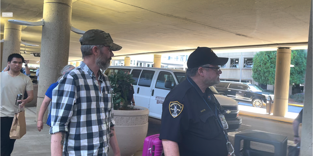 Andy Huynh, far left, and Alex Drueke, right, are seen leaving Birmingham-Shuttlesworth International Airport in Birmingham, Ala., Saturday, Sept. 24, 2022. The U.S. military veterans disappeared three months ago while fighting Russia with Ukrainian forces. They were released earlier this week by Russian-backed separatists as part of a prisoner exchange.