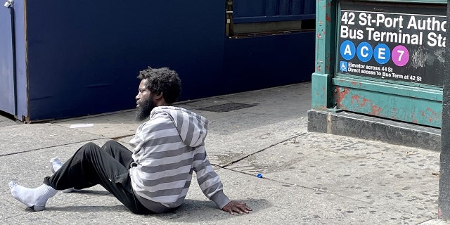 A man sat bleary-eyed on the corner of Eighth Avenue and West 44th Street in Midtown Manhattan on Monday, Sept. 12, 2022, outside one of the entrances to the Port Authority subway station. Some 350,000 visitors pass through Times Square each day just a block away.
