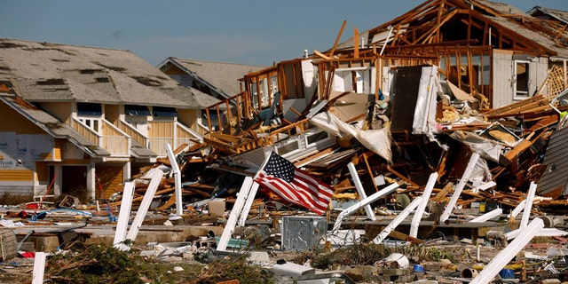 An American flag flies amid rubble left in the aftermath of Hurricane Michael in Mexico Beach, Florida, on Oct. 11, 2018.