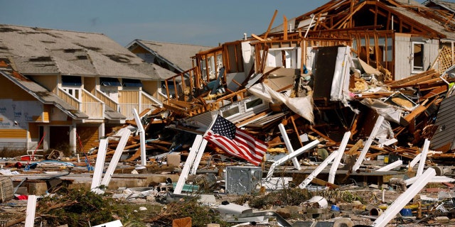 An American flag flies amongst rubble left in the aftermath of Hurricane Michael in Mexico Beach, Florida, U.S. October 11, 2018. 