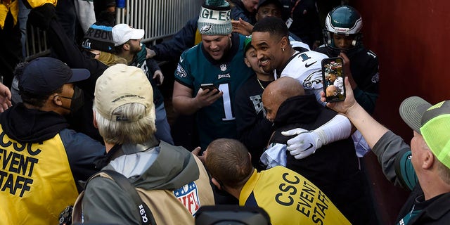 Jalen Harts of the Philadelphia Eagles celebrates with fans who fell to the ground after a railing collapsed following their 20-16 win over the Washington football team at FedEx Field on January 2, 2022 in Landover, MD.