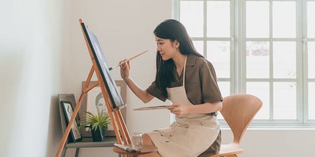 A woman creates art in her home studio. Hobbies that have no strings attached count as rest just as much as sitting and doing absolutely nothing at all, author Celeste Headlee suggested.