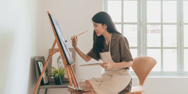 A woman creates art in her home studio. Hobbies that have no strings attached count as rest just as much as sitting and doing absolutely nothing at all, author Celeste Headlee suggested.  