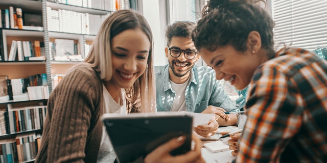 Friends working together in a library. "Friendship doesn't really happen organically in adulthood," said one psychologist. But there are skill sets based on science that can help. 