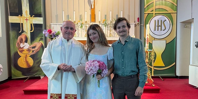 Jack Gleeson, Róisín O’Mahony and Father Patsy Lynch stand in front of the altar on their wedding day. 