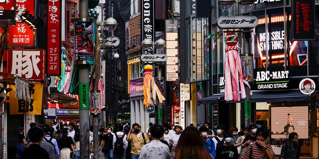 Pictured: People wearing face masks at the Shibuya shopping district in Tokyo, Japan, on July 28, 2022.  