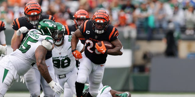 Joe Mixon (28) of the Cincinnati Bengals runs with the ball against Quincy Williams (56) of the New York Jets during the fourth quarter at MetLife Stadium Sept. 25, 2022, in East Rutherford, N.J.