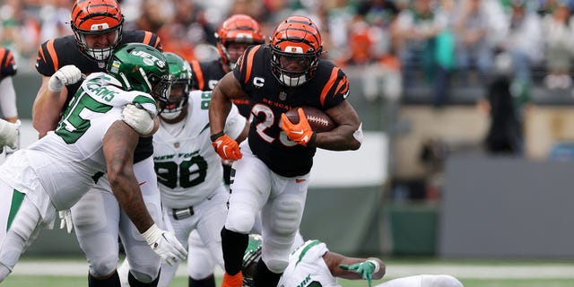 Joe Mixon (28) of the Cincinnati Bengals runs with the ball against Quincy Williams (56) of the New York Jets during the fourth quarter at MetLife Stadium Sept. 25, 2022, in East Rutherford, N.J.