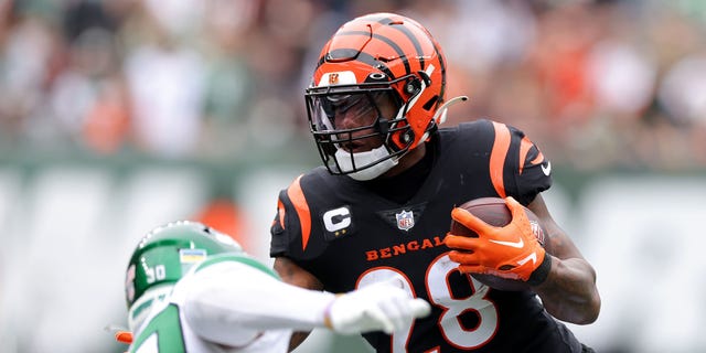 Joe Mixon (28) of the Cincinnati Bengals runs with the ball against Michael Carter II (30) of the New York Jets during the first quarter at MetLife Stadium Sept.  25, 2022, in East Rutherford, NJ