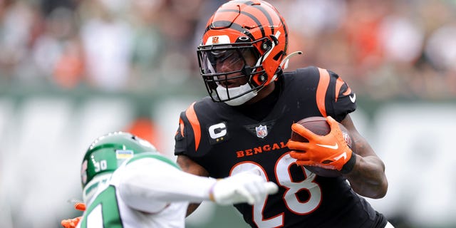 Joe Mixon (28) of the Cincinnati Bengals runs with the ball against Michael Carter II (30) of the New York Jets during the first quarter at MetLife Stadium Sept. 25, 2022, in East Rutherford, N.J.