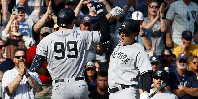 Anthony Rizzo of the New York Yankees congratulates Aaron Judge (99) after Judge's second home run of the game during the seventh inning against the Milwaukee Brewers at American Family Field in Milwaukee on Sept. 18, 2022.