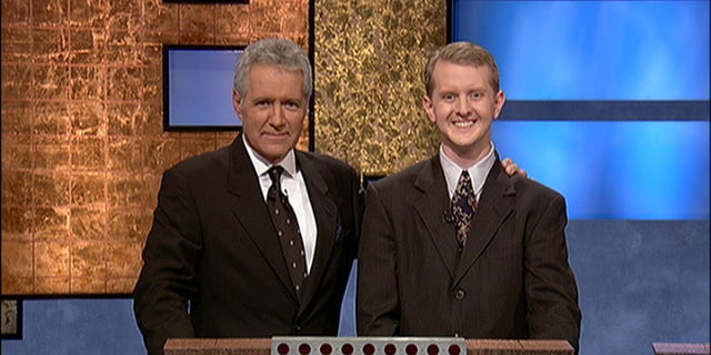 "Jeopardy!" host Alex Trebek, (L) poses with contestant Ken Jennings after his earnings from his record-breaking streak on the game show surpassed $1 million on July 14, 2004 in Culver City, California.