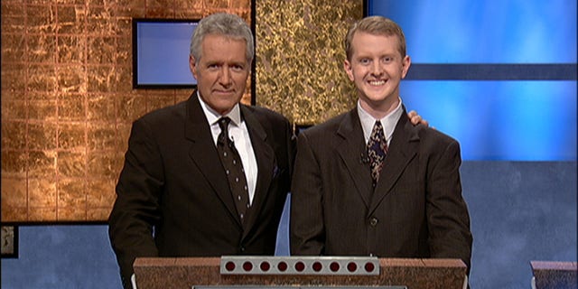 "Jeopardy!" host Alex Trebek, (L) poses with contestant Ken Jennings after his earnings from his record-breaking streak on the game show surpassed $1 million on July 14, 2004 in Culver City, California.